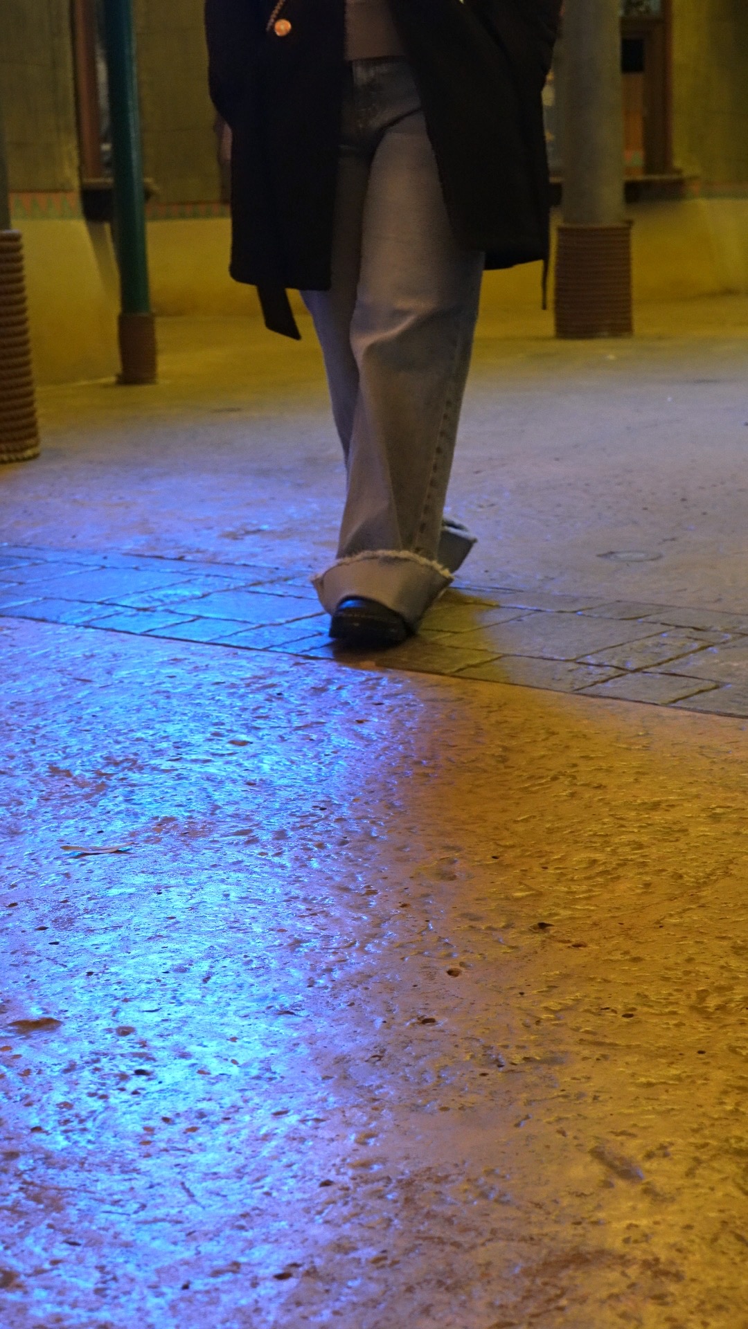 Shoes crossing reflected city light